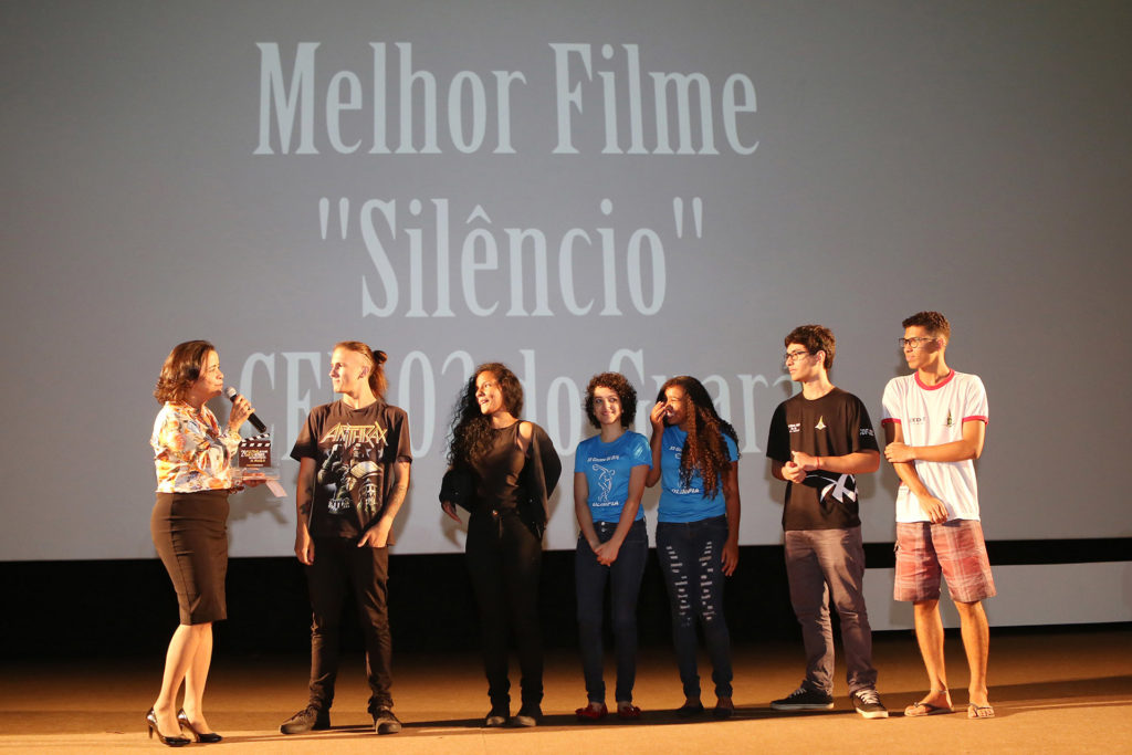 A colaboradora do governo Márcia Rollemberg entrega o prêmio de melhor filme aos estudantes que produziram, Silêncio. 