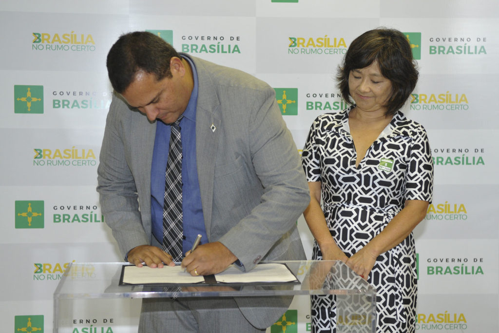 O presidente da FAP-DF, Tiago Coelho, assina os termos acompanhado da decana de pós-graduação da UnB, Helena Eri Shimizu.