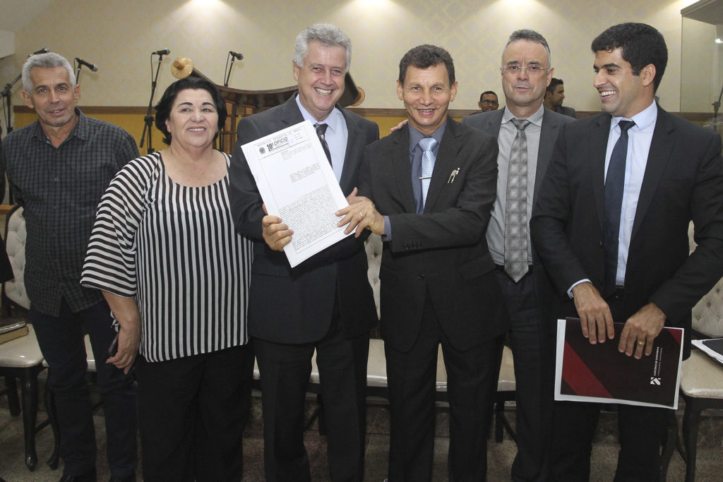 O pastor Adomício Pereira de Sousa recebe a escritura das mãos do governador Rollemberg.