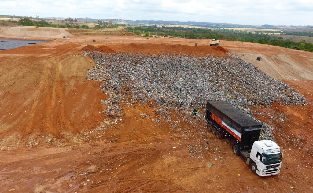 Imagem aérea de um caminhão no Aterro Sanitário de Brasília. Há muito lixo atrás do caminhão.