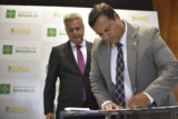 O diretor-presidente da FAP-DF, Tiago Coelho, assina os editais acompanhado do governador Rollemberg. Foto: Andre Borges/Agência Brasília